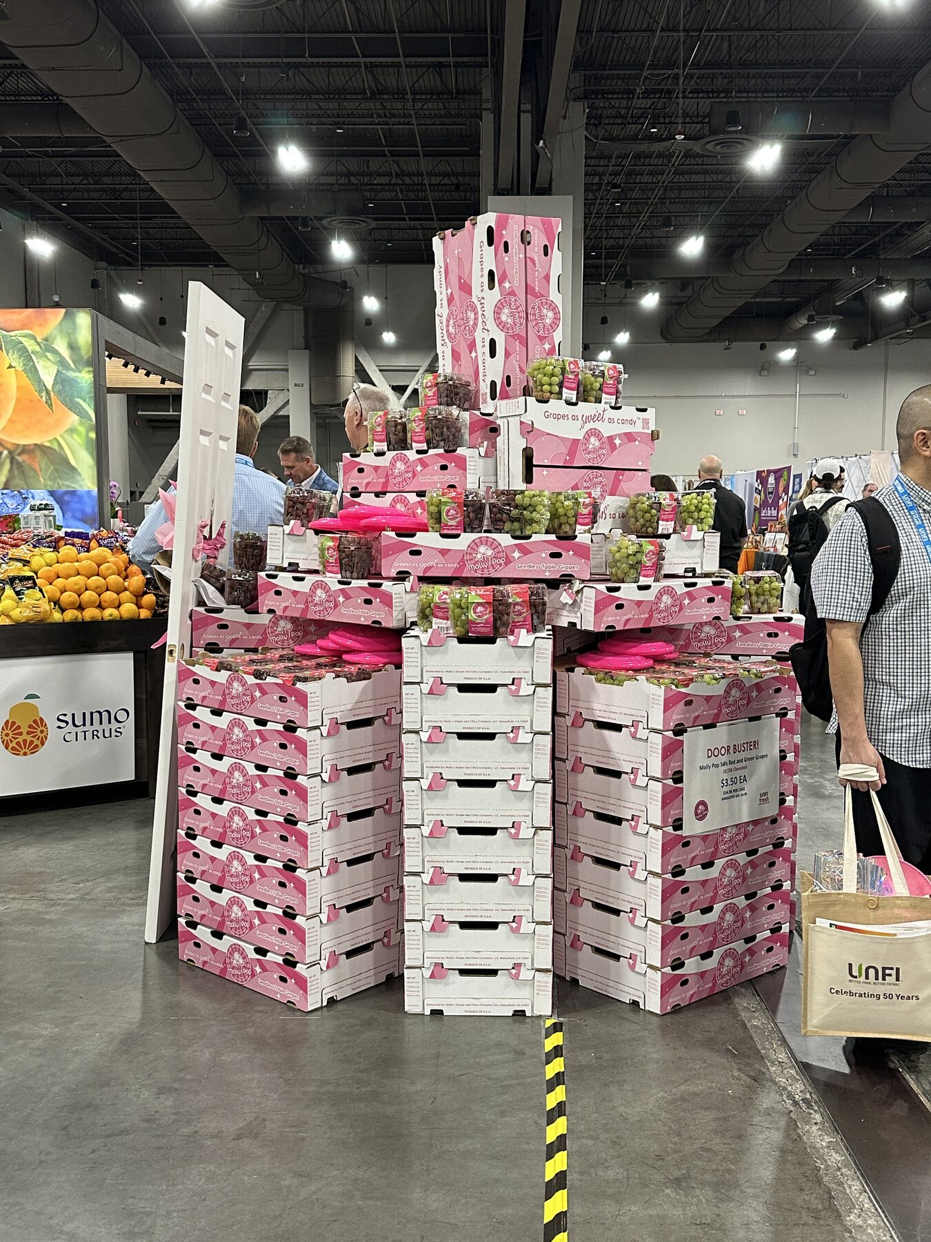 Full Molly Pop grape tower built from pink branded cases and clamshells at UNFI Las Vegas